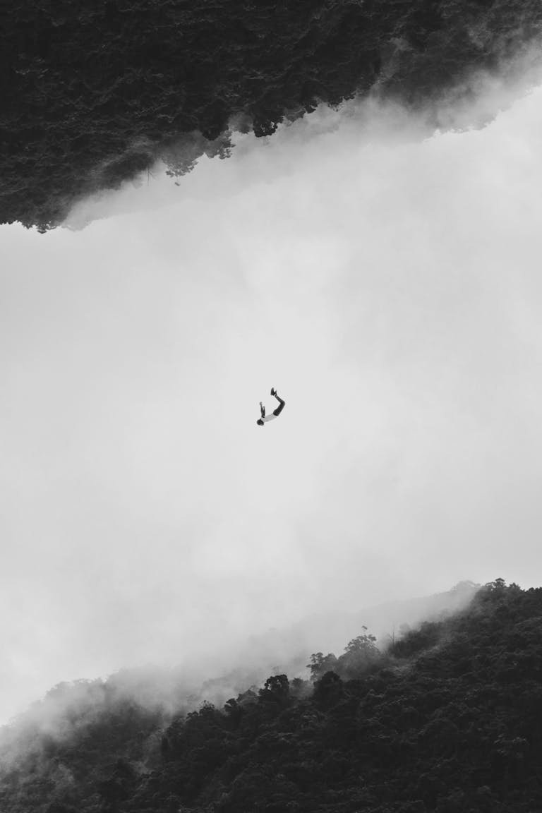 Silhouetted person mid-air against a fog and forest backdrop in Shiding District, Taiwan.