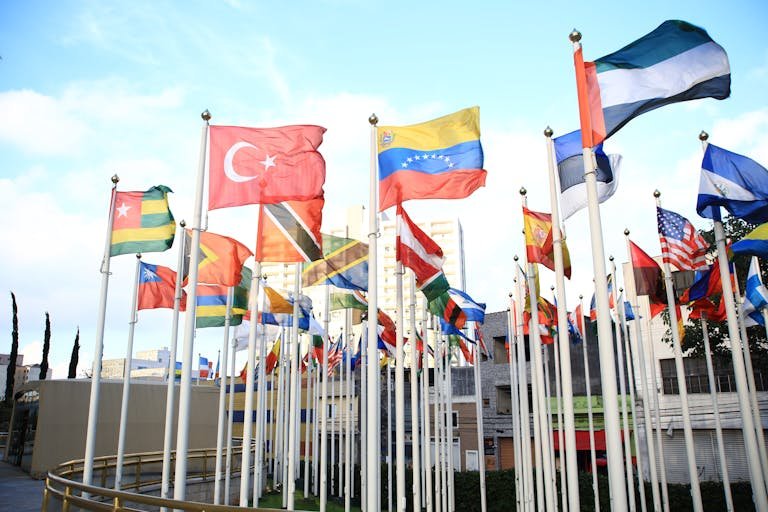 A vibrant collection of international flags in a cityscape setting, symbolizing global unity.